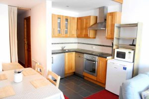 Open plan kitchen with full-size integrated oven, coffee machine, fridge and dishwasher
