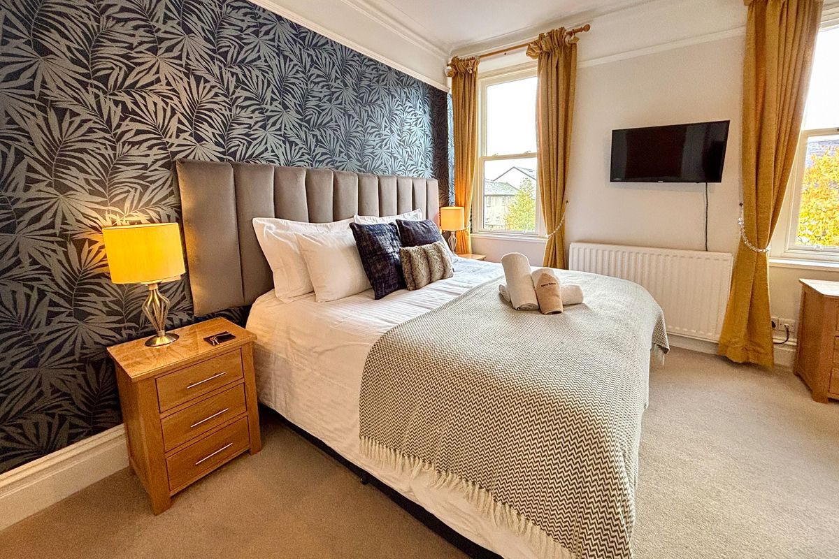 Room 2 – Double room with feature wall, super-kingsize bed and natural light.