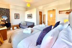 Room 2 – Twin room with two comfortable beds and a stylish feature wall.