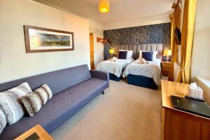 Room 2 – Modern twin room with soft textures and a bright, airy feel.