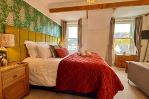 Room 4 – Spacious double room with feature wall, plush bedding and fell views.