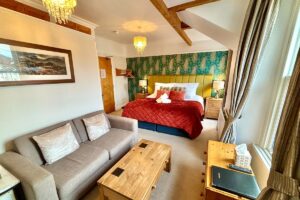 Room 4 – Double room with seating area, warm lighting and vibrant décor.