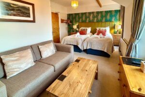 Room 4 – Spacious twin layout with sofa seating and natural light.
