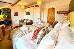 Room 4 – Twin beds with cosy textures and vibrant cushions.